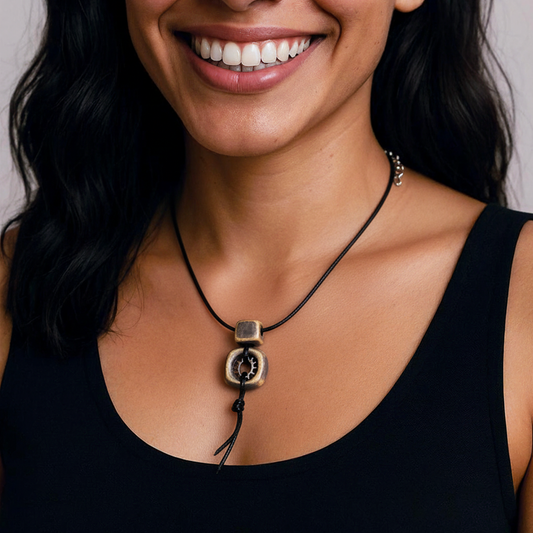 Woman wearing a necklace with a large pendant against a neutral background