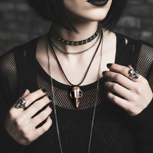Person wearing multiple necklaces and rings with a dark background