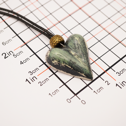 Heart-shaped pendant on a cord with measurement scale